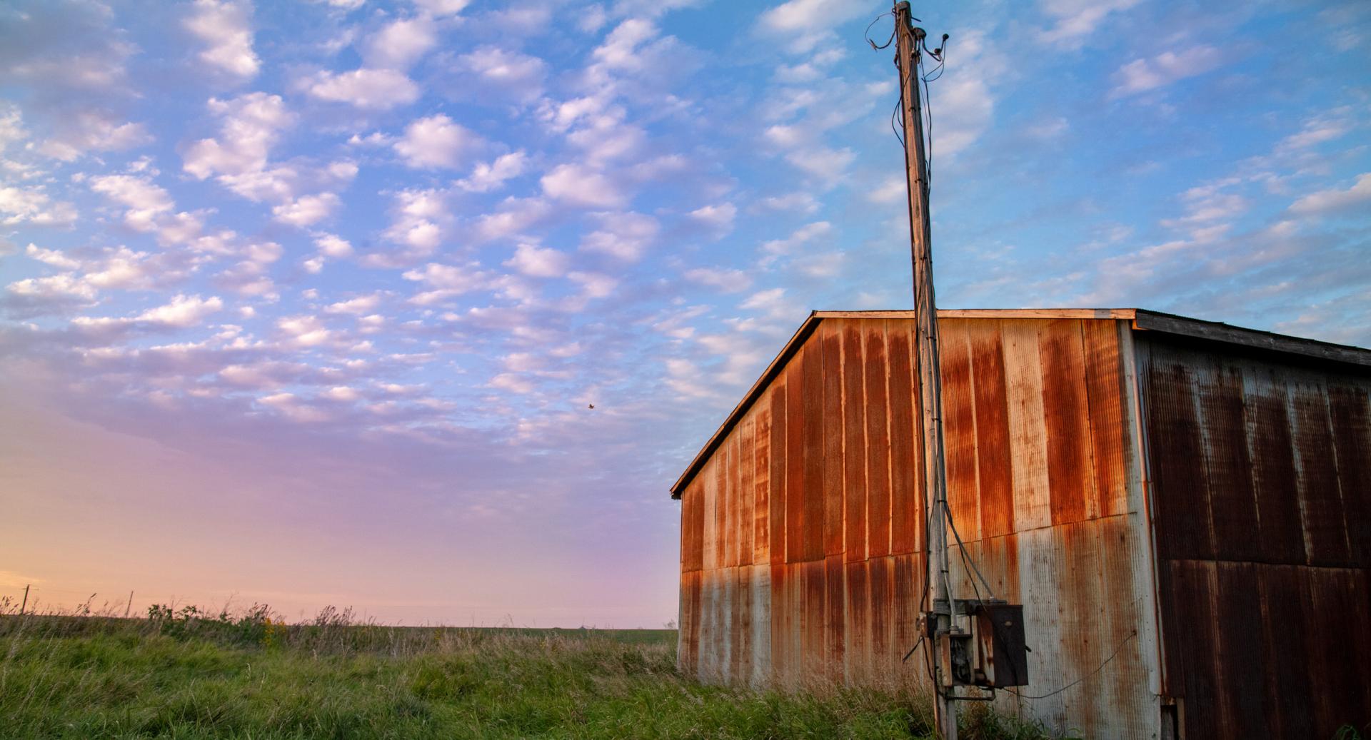 Barn in a field at dusk.