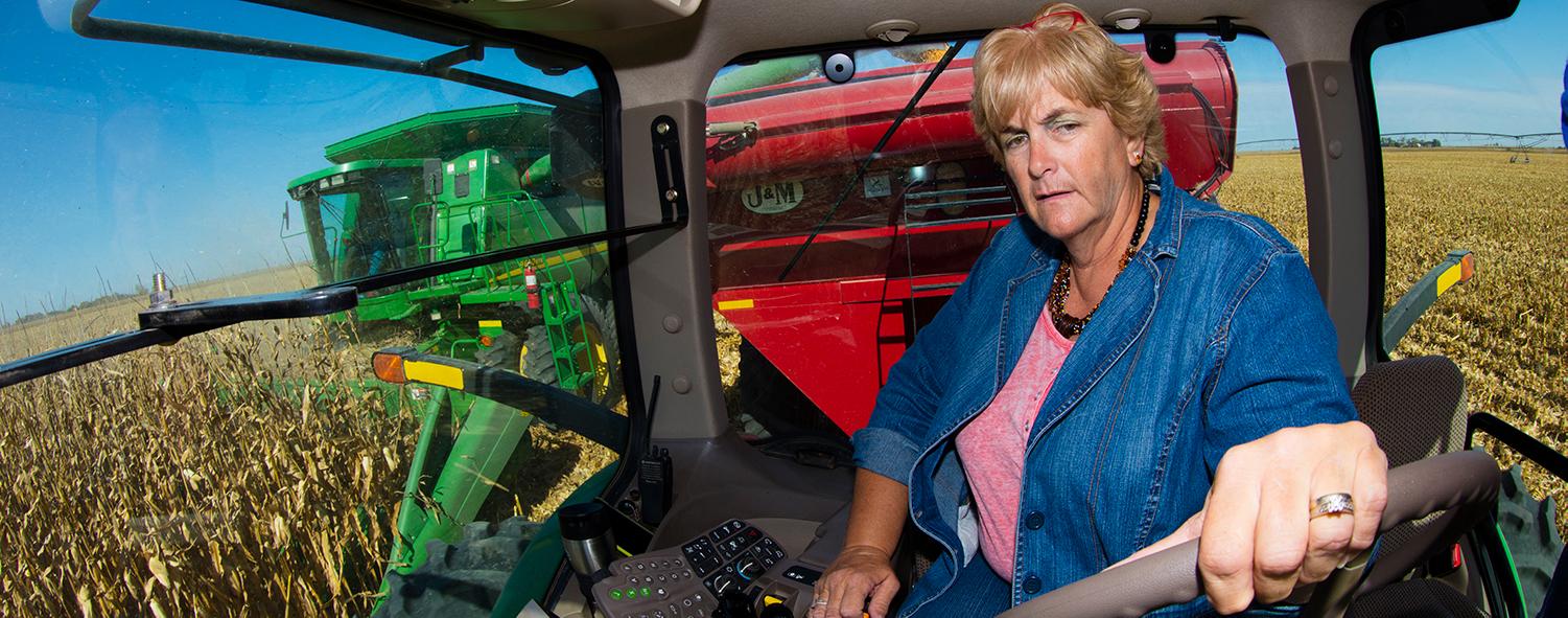 Woman driving harvester.