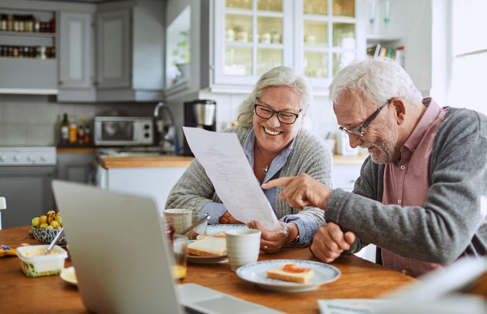 Older couple reviewing documents at the kitchen table