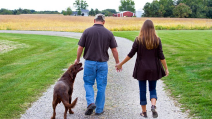 Couple walking with their dog.