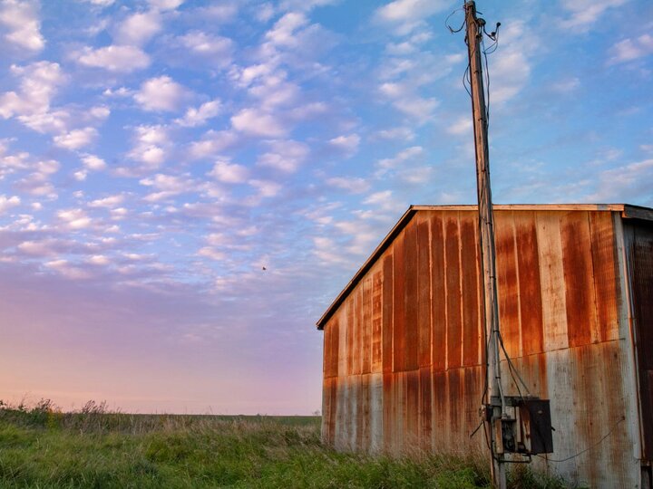 Barn in a field at dusk.
